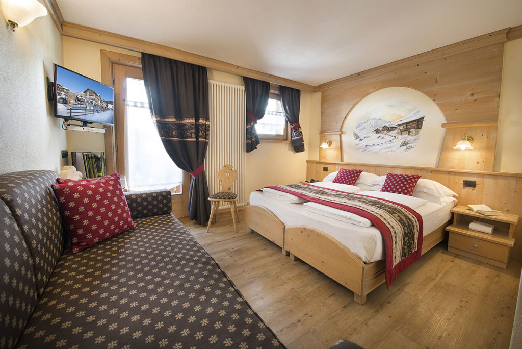 Camera Comfort con letto matrimoniale, divano e tende scure